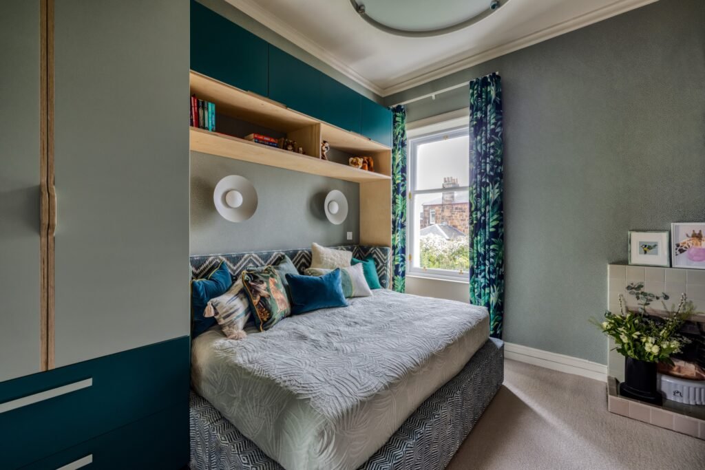 Stylish gray and teal bedroom featuring a custom bed with integrated shelving, tropical leaf curtains, and textured wallpaper.