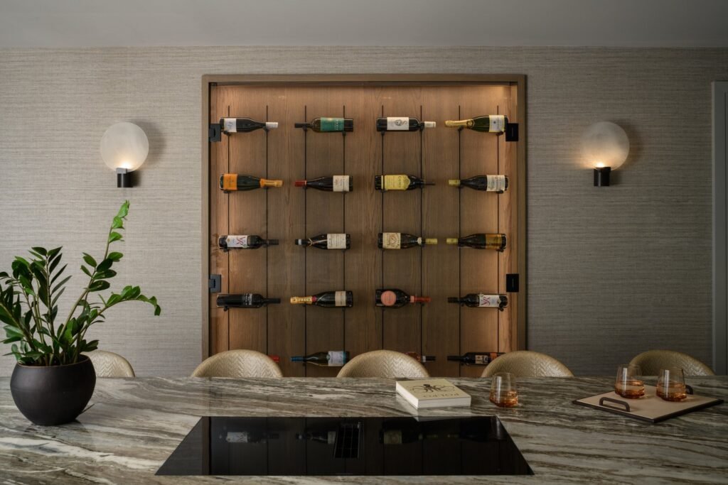 Contemporary dining room with an illuminated wooden wine wall, a long veined marble table, and soft wall sconces.