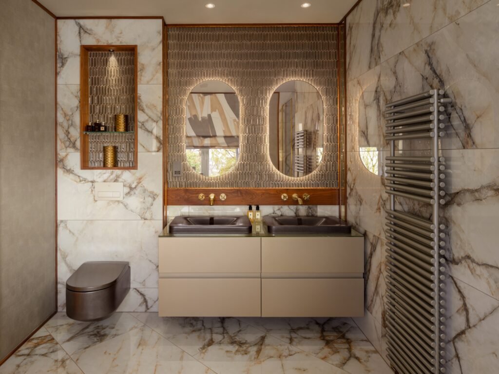 Luxurious bathroom: white and gold marble, accent tile wall, double vanity, illuminated arched mirrors, and heated towel rack.